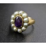 An 18ct gold ring, inset central amethyst cabochon, surrounded by eleven pearls, gross weight: 7.8g
