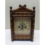 A 19th century mantel clock, the mahogany case carved bamboo effect, the dial with Roman numerals, 3