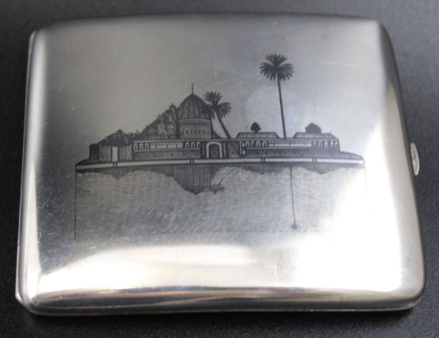 An Iraqi Niello white metal cigarette case, decorated with river scenes to either side, 8cm x 9cm,