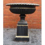 An impressive black cast iron metal urn with everted egg and dart rim over a fluted body fluted foot