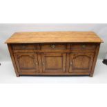 A well made reproduction oak dresser, planked top over three inline drawers & three cupboard doors,