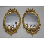 A pair of late 19th century continental gilt framed Girondelle wall mirrors with candle sconces