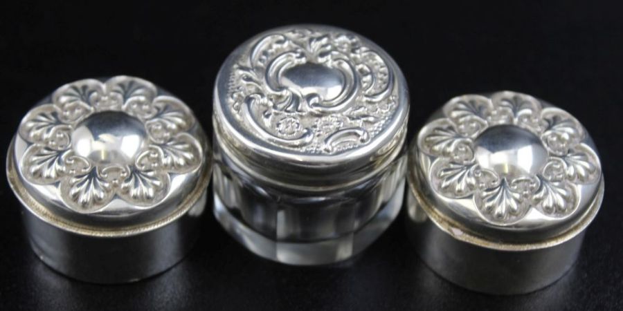 A pair of small silver pill boxes with embossed lids and gilt interiors 3cm diameter, Birmingham 190