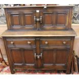 An Ercol buffet with twin upper cupboard doors on a deeper base unit, with twin drawers & further do