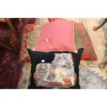 A King Charles needlework cushion, two pink Heraldic, and one small pink cushion