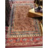 A machine made woven wool Kerman style rug, red / green