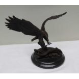 A reproduction bronze effect model of an eagle landing, on a polished plinth base, 19cm high