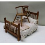 An early 20th century doll's bed, with bedding, 46cm x 34cm, together with a doll's horseshoe back c