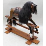 A 20th century rocking horse, of Victorian design with real mane & tail on stained pine base