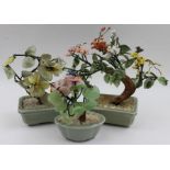 Three imitation Bonsai tree ornaments, each in celadon bowls, the leaves and petals modelled from va