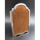 Sanders & Mackenzie, An early 20th century silver photograph frame, arch top, polished wood back wit