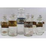 A collection of nine various chemist bottles, with stoppers, all but one have labels, the largest is