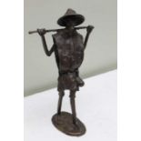 A bronze standing male figure of an oriental field worker 31cm tall