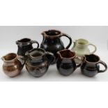 A collection of four Winchcombe pottery glazed stoneware jugs, of various sizes, and three other stu