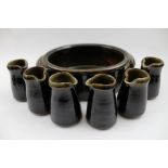 A set of six glazed stoneware, individual serving jugs, together with a Winchcombe