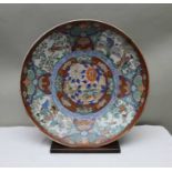 A large 19th century Imari charger with figures & birds around the edge, floral centre & underneath
