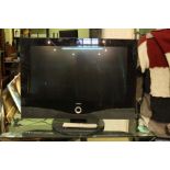 A Loewe branded flat screen television with remote control