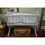 A white painted rocking wooden crib