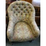 A Victorian upholstered button back armchair having showwood legs & ceramic castors