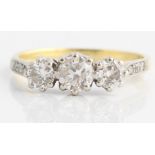 A diamond ring, set with three principal graduated round brilliant cut diamonds, with further