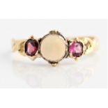A 14ct yellow gold opal and garnet three stone ring, set with a central round opal cabochon,