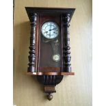 A mahogany wall clock with Roman numerals.