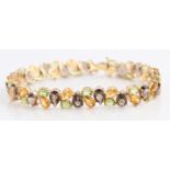 A peridot, citrine and smoky quartz bracelet, set with alternating oval cut peridots, pear cut