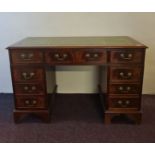 A mahogany reproduction twin pedestal desk with green leather inserts to the top