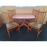A Ercol Windsor extending dining table with four chairs.