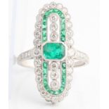 An early 20th Century style emerald and diamond ring, the oval head set with a central emerald cut