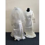 A vintage wedding dress, along with a collection of other vintage dresses and clothes.