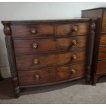 A Victorian mahogany bow front chest of drawers with turned column supports.