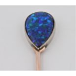 A black opal stick pin, set with a pear cut opal cabochon, measuring approx. 15x9mm, unmarked rose