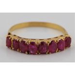 A ruby half eternity ring, set with eight graduated oval cut rubies, unmarked yellow metal, ring