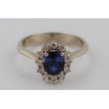 A sapphire and diamond cluster ring, set with an oval cut sapphire, measuring approx. 7x5mm,