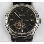 A gents Bulova automatic wristwatch, the black dial having hourly baton markers, displayed mechanism