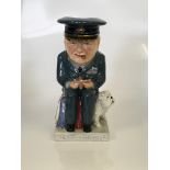 Large caricature jug of Winston Churchill in RAF uniform seated on a Bulldog. Inscribed on plinth “