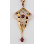 An Edwardian garnet pendant, the open metalwork design set with two round cut garnets, stamped