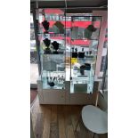 A shop display unit with two glazed door sections with locks and internal glass shelves on storage