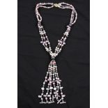 A triple strand string of cultured pearls in gathered design, comprising pink, purple white and