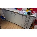 An under counter three door cupboard unit with seven drawer section to side.(Contents not