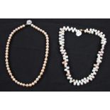 A string of peach cultured pearls with gold-tone spacers, clasp stamped 375, length approx. 16",