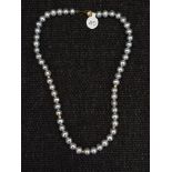 A string of grey cultured pearls, with gold-tone spacers, clasp stamped 375, length approx. 15".