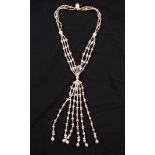 A triple strand string of cultured pearls in gathered design, comprising white, peach and