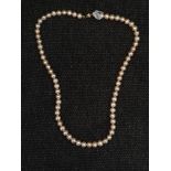 A string of peach cultured pearls, clasp stamped 375, length approx. 20" IMPORTANT: Bidding via