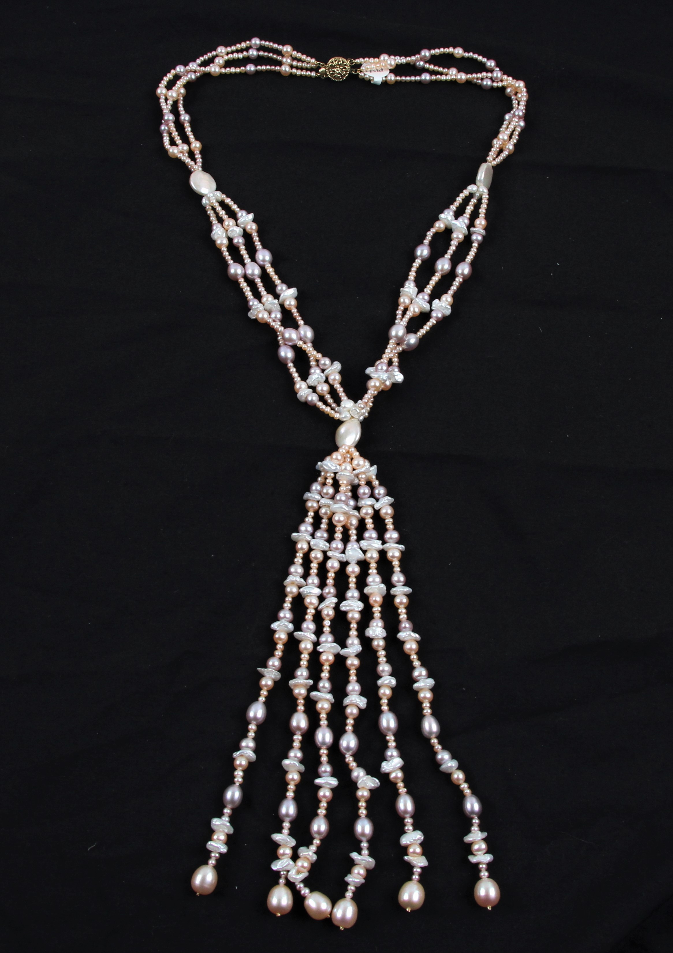 A triple strand of cultured pearls in gathered design, comprising spherical, oval and baroque