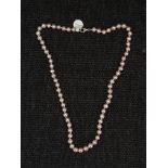 A string of purplish pink cultured pearls, clasps stamped 925, lengths approx. 18". IMPORTANT: