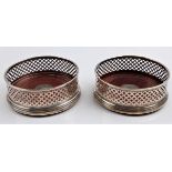Two matched hallmarked silver wine coasters of openwork pattern and wooden base, approx. diameter