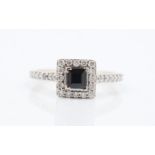 A hallmarked 18ct yellow gold sapphire and diamond ring, set with a central square cut sapphire,