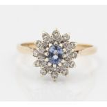 A hallmarked 9ct yellow gold sapphire and diamond cluster ring, set with a central oval cut